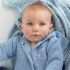 A baby wearing personalised with the a blue cardigan embroidered with the letter T.