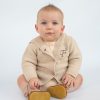 Baby wearing personalised cardigan embroidered with the letter f.