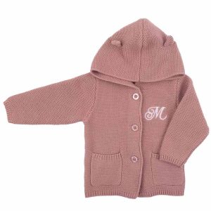 A blush pink hooded knitted baby cardigan personalised with a fancy embroidered initial.