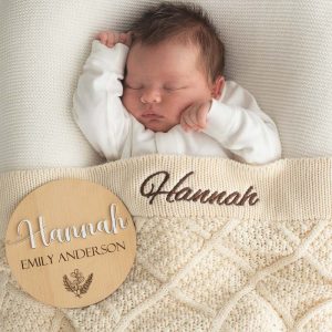 A baby laying under a Personalised Cream Diamond Blanket & 3D Baby Name Disc.