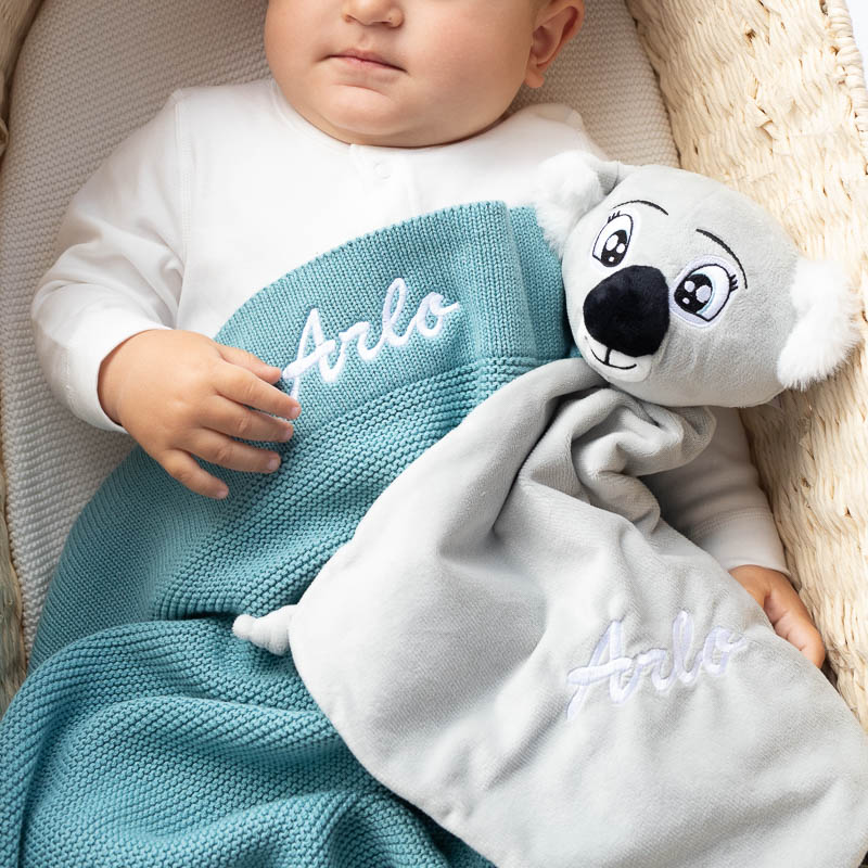 Baby with personalised koala comforter and ocean blue blanket newborn gift.