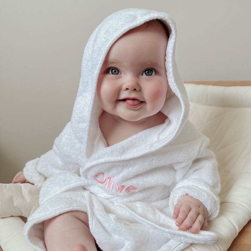 Baby girl wearing personalised white hooded bath robe 1 year old gift.