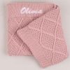 A blush pink knitted diamond baby blanket personalised with the girls name Olivia.