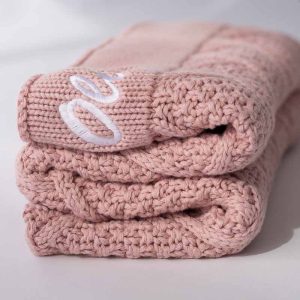 A blush pink knitted diamond blanket with embroidery gift for newborn girls.