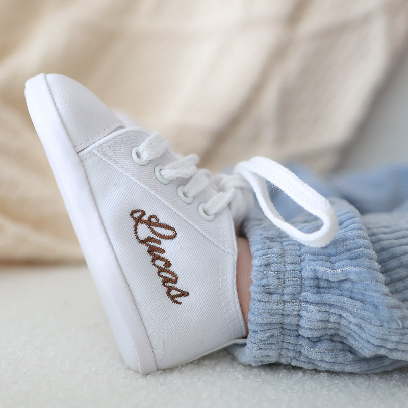 Personalised white baby shoes embroidered with boys name Lucas.