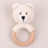 An off-white, hand-crocheted and bear baby teether with a beech-wood ring.