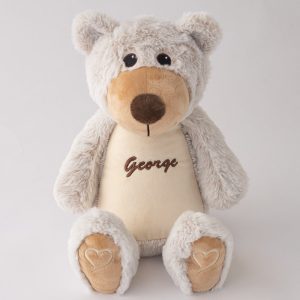 A personalised teddy bear embroidered with the name George using brown thread.