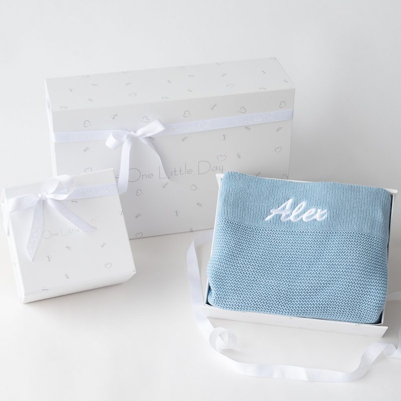 Personalised blue knitted baby blanket in gift box with ribbon.