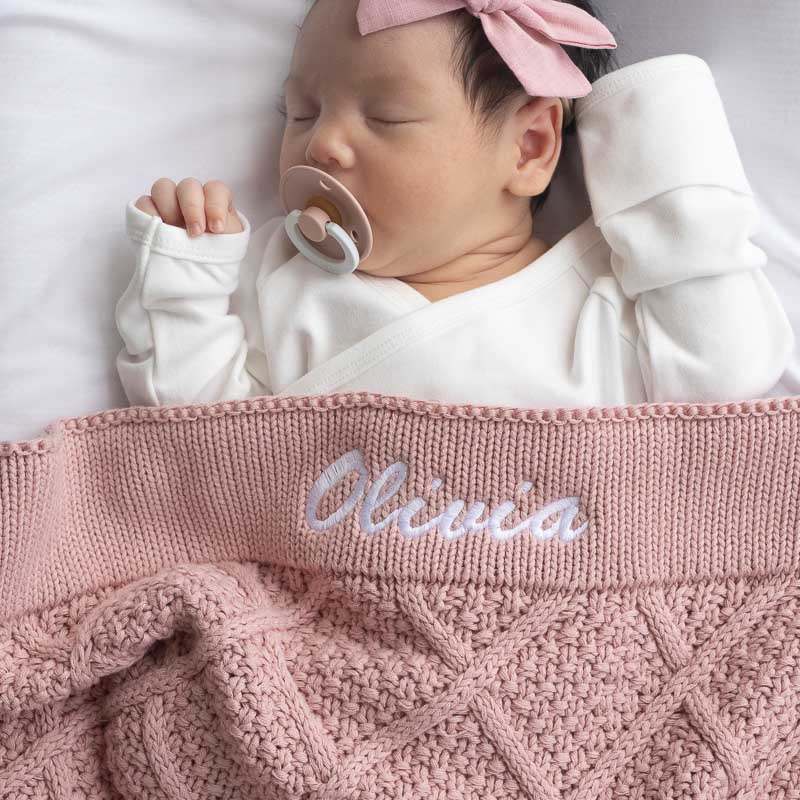 Blush pink diamond knitted personalised baby blanket with the name Olivia.