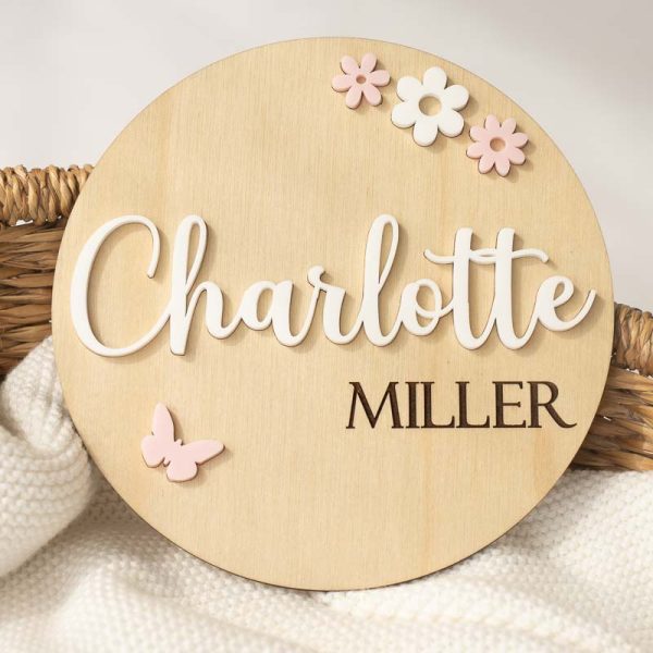 A wood birth disc featuring acrylic flowers and butterflies with the name Charlotte.